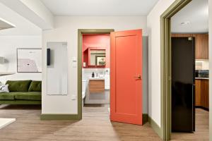 a room with a red door and a kitchen at GuestReady - The Bridge - Wealdstone in London +94 photos
