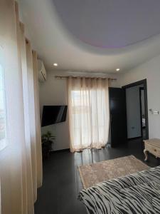 a bedroom with a bed and a window with a tv at Dar ZYED in Houmt Souk