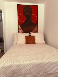 a bedroom with a bed with a painting above it at Heritage Suites- Palais des Papes & Pont d'Avignon- Clim in Avignon