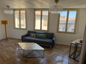 a living room with a couch and a table at Heritage Suites- Palais des Papes & Pont d'Avignon- Clim in Avignon +5 photos
