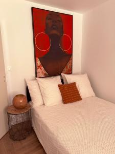 a bedroom with a bed with a painting above it at Heritage Suites- Palais des Papes & Pont d'Avignon- Clim in Avignon