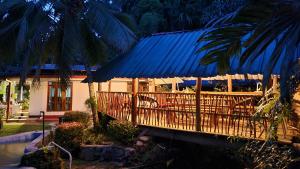 a house with a blue roof with a porch at Merlot in Deniyaya