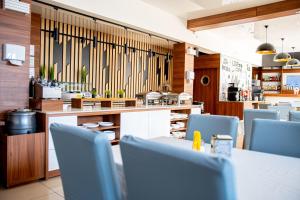 a restaurant with blue chairs and a counter and tables at Holiday Home Resort & Spa in Jarosławiec