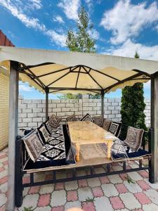 a table and chairs under an umbrella on a patio at Aknur Deluxe hotel in Cholpon-Ata