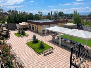 a patio with white umbrellas and a building at Aknur Deluxe hotel in Cholpon-Ata