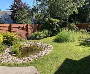 a backyard with a fence and a pond in the grass at Fairways in Cleveleys