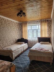 a bedroom with two beds and a window at Hotel Sarytag in Sarytag