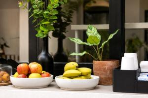 a table with two bowls of fruit on it at Aruma Suites in Playa del Carmen