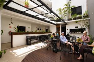 a group of people sitting at tables on a patio at Aruma Suites in Playa del Carmen