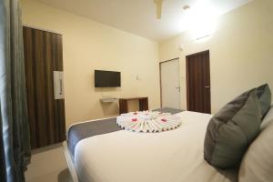a hotel room with a bed with a cake on it at Nature's Glory Resort in Panchgani