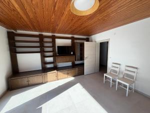 a living room with a television and two chairs at WiLDBED DE in Bad Wildbad