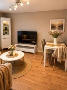 a living room with a television and a table and chairs at Leilighet Preikestolen in Strand