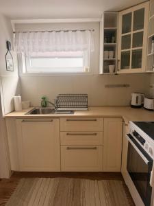 a small kitchen with a sink and a window at Leilighet Preikestolen in Strand +3 photos