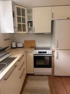 a white kitchen with white cabinets and a stove at Leilighet Preikestolen in Strand