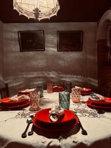 a table with red plates and glasses on it at Trnova Ruzica in Trnovac