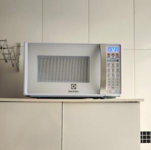 a microwave oven sitting on top of a kitchen counter at AP 3 quartos -2min da ARENA MRV e Expominas- BH in Belo Horizonte