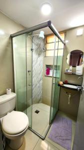 a bathroom with a toilet and a glass shower at AP 3 quartos -2min da ARENA MRV e Expominas- BH in Belo Horizonte +17 photos