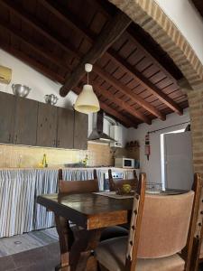 Eine Küche mit einem Holztisch, Stühlen und einer Theke in der Unterkunft Casa da Muralha - Avis in Avis