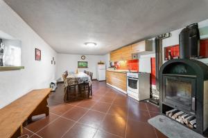 a kitchen with a fireplace and a table in a room at Horská chata ERIK in Levoča