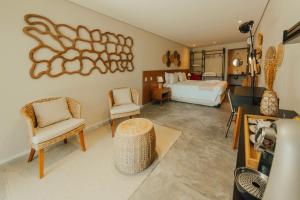 a bedroom with a bed and two chairs in a room at Pousada Moana in Fernando de Noronha