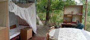 a bedroom with a bed and a desk and a tree at погружение в природу in Drăsliceni