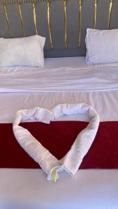 a bed with a heart shaped towel on it at Maea wade ram in Disah