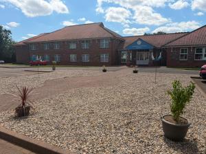 a building with a courtyard with plants in front of it at Northallerton Motel in Northallerton