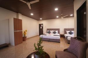 a living room with two beds and a couch at Nature's Glory Resort in Panchgani