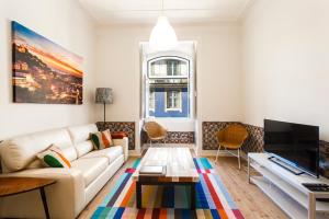 uma sala de estar com um sofá e uma televisão em WHome | Fanqueiros Downtown Typical Apartment em Lisboa