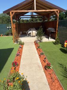a garden with a wooden pavilion with plants and flowers at Casa Theopa in Corbu