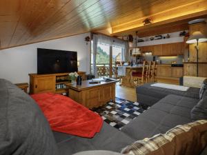 a living room with a couch and a flat screen tv at Apartment Mon Abri B by Interhome in Les Diablerets