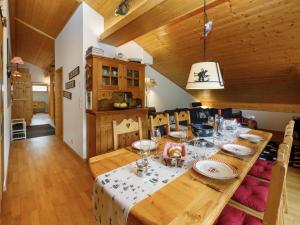 a dining room with a wooden table with plates and glasses at Apartment Mon Abri B by Interhome in Les Diablerets