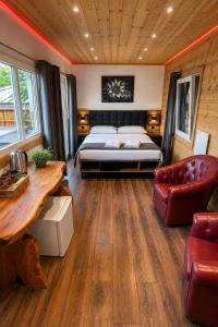 a bedroom with a bed and a desk and a couch at Les chambres et Roulottes des Noisetiers in Leysin