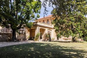 an old house with a tree in front of it at Maison Martina in Rivoli