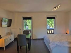a bedroom with a bed and a desk and a table at Studio Le Vedeur in Durbuy