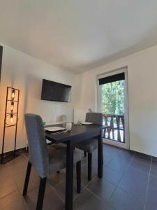 a dining room with a table and chairs and a window at Studio Le Vedeur in Durbuy