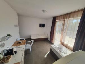 a small room with a desk and a bed and a table at Apartments Lozenets in Lozenets