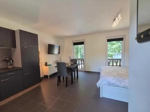a bedroom with a bed and a desk and a table at Studio Le Vedeur in Durbuy