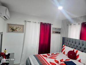 a bedroom with red and white curtains and a bed at Peace Place in Santiago de los Caballeros