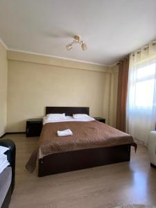 a bedroom with a bed with two towels on it at Aknur Deluxe hotel in Cholpon-Ata