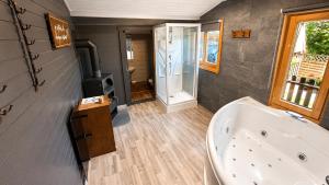 a bathroom with a tub and a stove at Les chambres et Roulottes des Noisetiers in Leysin