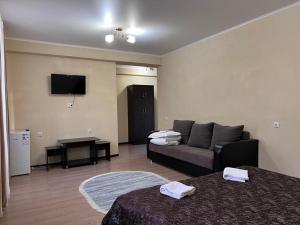 a living room with a couch and a flat screen tv at Aknur Deluxe hotel in Cholpon-Ata
