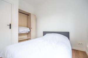 a bedroom with a white bed and a closet at T2 Cosy - Amiens Centre - Wifi in Amiens