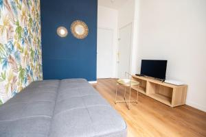 a bedroom with a bed and a desk with a television at T2 Cosy - Amiens Centre - Wifi in Amiens