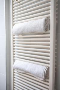 a towel rack with white towels in a bathroom at T2 Cosy - Amiens Centre - Wifi in Amiens +39 photos