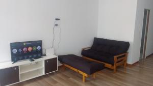a living room with a chair and a television at La Morada en Funes in Funes