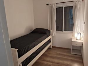 a small bedroom with a bed and a window at La Morada en Funes in Funes +4 photos