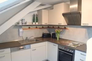 a kitchen with white cabinets and a sink at Schullandheim Neukirch Lausitz in Meyershäuser