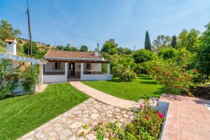 a garden with a house with a lawn at Cubo's Charming House Las Millanas in Tolox
