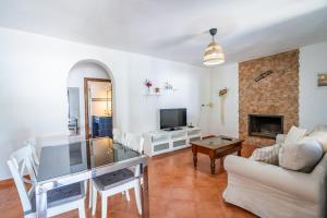 a living room with a couch and a tv at Cubo's Charming House Las Millanas in Tolox